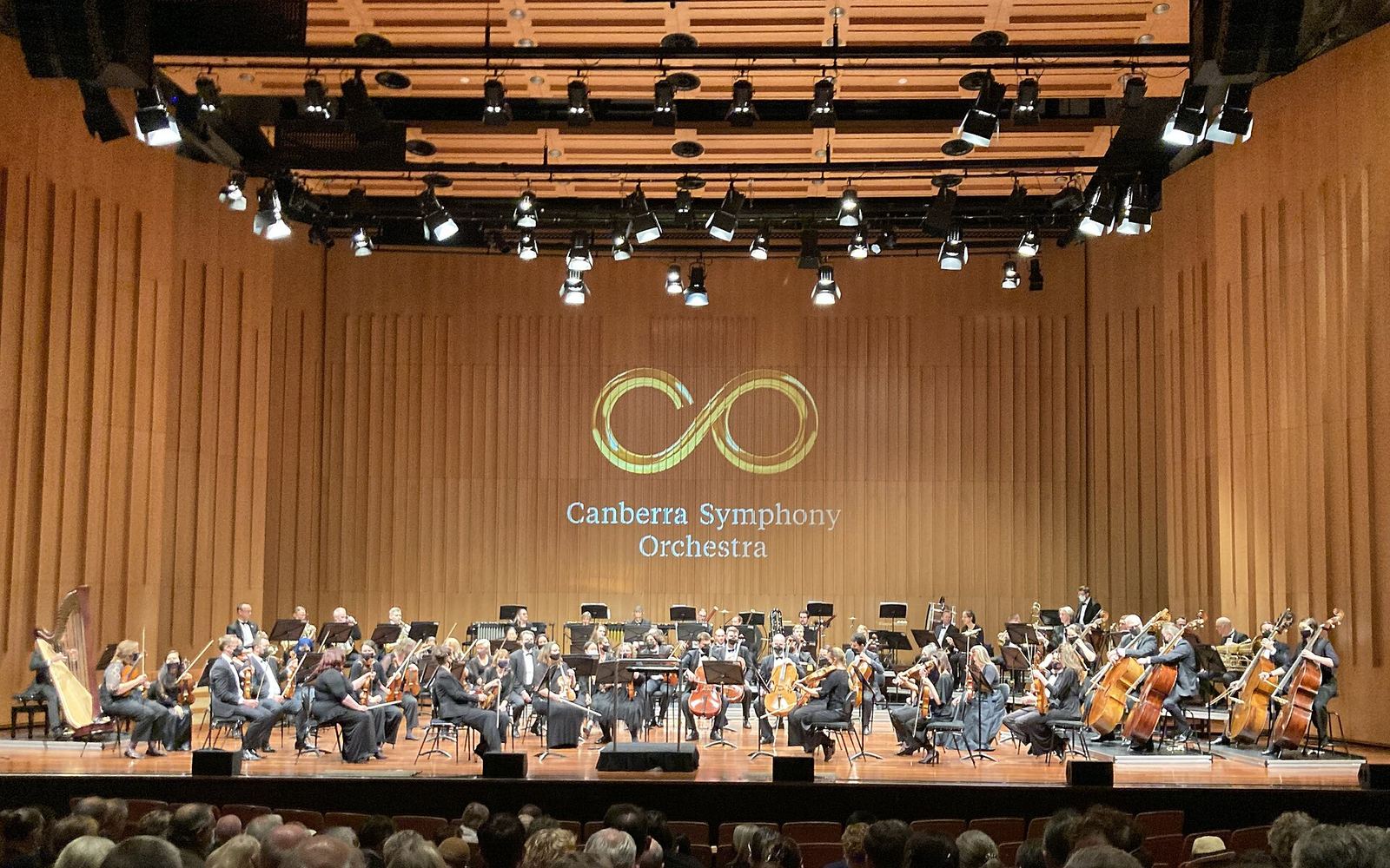 An orchestra performing on a concert hall stage